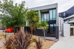 a modern house with a black fence and some plants at Large Executive 3 bedroom in Yarralumla