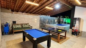 a ping pong room with a ping pong table at Casa Pé na Areia com Piscina Climatizada in Bertioga