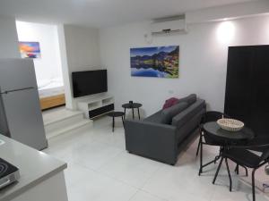 a living room with a couch and a tv at המקום ברותם in Nahariyya