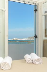 a room with a window with towels on a bed at White Cedar Villa in Stelida