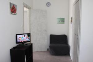 een woonkamer met een televisie en een stoel bij B&B Fili d'erba in Farra dʼlsonzo