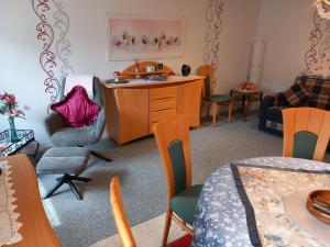 a living room with a desk and chairs at Gemütliche 3 Zimmer-Ferienwohnung in Langelsheim