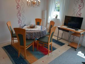 a dining room with a table and chairs and a television at Gemütliche 3 Zimmer-Ferienwohnung in Langelsheim