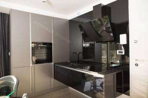 a kitchen with a sink and a tv on a wall at Luxury apartment Jakov in Njivice +4 photos