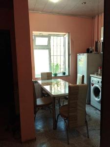 a kitchen with a table and chairs and a window at 2-storey apartment in Mardakan