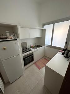 a kitchen with white cabinets and a stove top oven at Casa di Marilena in Galatina