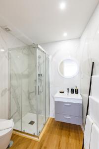 uma casa de banho branca com um chuveiro e um WC. em Pestana Apartments - In city center, Modern, New and Cozy no Porto