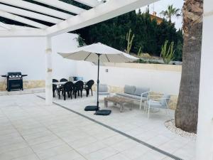 a patio with an umbrella and a table and chairs at Casa Evie in El Campello