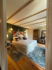 1 dormitorio con 1 cama con una pintura en la pared en Le clos de l’Âne Dentelle, en Vézac
