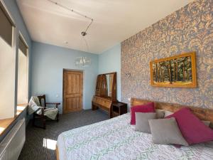 a bedroom with a bed and a chair in a room at Lielbornes Muiža Boutique Hotel&Recreation Complex in Lielborna
