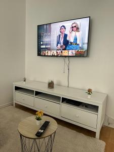 een woonkamer met een flatscreen-tv aan de muur bij Appartement cosy proche Stade de france - JO PARIS 2024 in Le Blanc-Mesnil