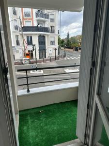 een raam met uitzicht op een groene tuin bij Appartement cosy proche Stade de france - JO PARIS 2024 in Le Blanc-Mesnil