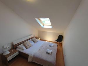 a bedroom with a large bed with a skylight at RITA - Charming 2-Bedroom Apartment with sea view, Slano in Slano