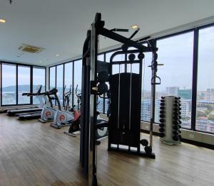 a gym with cardio equipment in a building with windows at Sky homestay in Kota Kinabalu