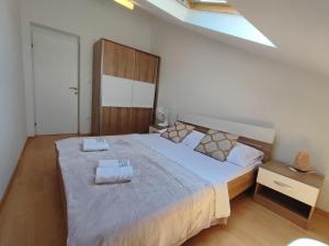 a bedroom with a large bed with two towels on it at RITA - Charming 2-Bedroom Apartment with sea view, Slano in Slano