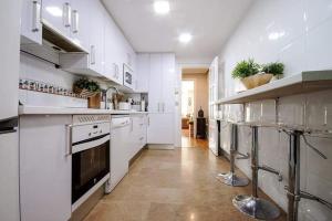 una gran cocina blanca con armarios y electrodomésticos blancos en Apartamento + parking en el centro de Cartagena en Cartagena