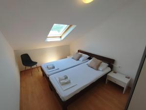 um pequeno quarto com 2 camas e uma clarabóia em RITA - Charming 2-Bedroom Apartment with sea view, Slano em Slano