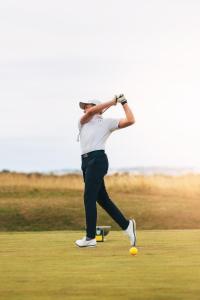 Ein Mann, der auf einem Golfplatz Golf spielt. in der Unterkunft Dornoch Station in Dornoch