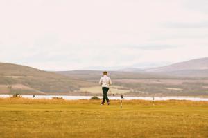 Ein Mann, der auf einem Golfplatz läuft in der Unterkunft Dornoch Station in Dornoch