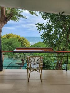 una sedia in rattan seduta su un balcone con vista di Haadson Resort & Koh Raham a Haad Son