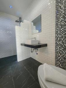 a white bathroom with a sink and a mirror at Haadson Resort & Koh Raham in Haad Son