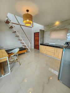 a living room with a staircase and a table at Haadson Resort & Koh Raham in Haad Son