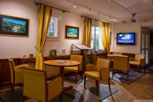 a waiting room with tables and chairs and a tv at Hotel Princess in Vernet-les-Bains