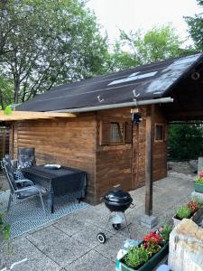 a barbecue grill in front of a wooden shed at Ferienhaus_natikrausz 