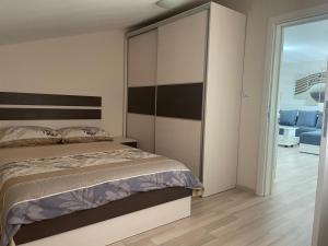 Schlafzimmer mit einem Bett mit einem großen Kopfteil in der Unterkunft Apartmani Vrla in Vladičin Han