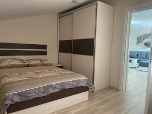 a bedroom with a bed with a large headboard at Apartmani Vrla in Vladičin Han