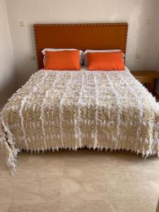 ein Bett mit zwei orangenen Kissen darüber in der Unterkunft Appartement gueliz Majorelle in Marrakesch