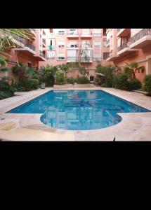 einem großen Pool vor einem Gebäude in der Unterkunft Appartement gueliz Majorelle in Marrakesch