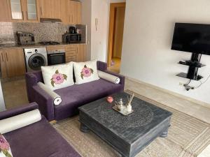 ein Wohnzimmer mit einem lila Sofa und einem Couchtisch in der Unterkunft Appartement gueliz Majorelle in Marrakesch