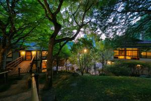 a house with a porch and a tree in front of it at Yumoto Ueyama Ryokan in Himeji
