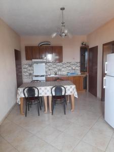 a kitchen with a table and chairs and a refrigerator at Villa Balliu in Pogradec +16 photos