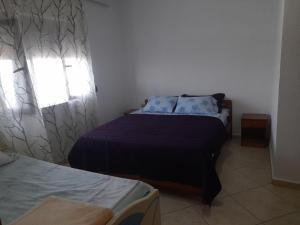 1 dormitorio con 2 camas y ventana en Villa Balliu, en Pogradec