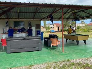 a covered patio with a ping pong table and a pool table at Axe Apartments in Solwezi