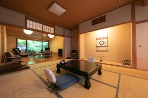 a large living room with a table and chairs at Yumoto Ueyama Ryokan in Himeji