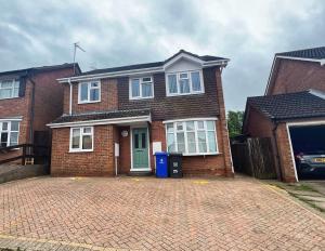 a brick house with a driveway in front of it at Modern comfortable quiet self contained apartments in Brackley