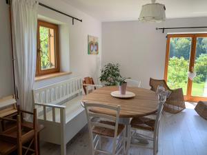 a dining room with a wooden table and chairs at Green place in Žetale
