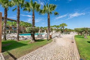 a path with palm trees and a resort at Herdade dos Salgados Harmonia in Guia