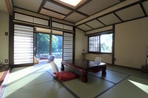 a room with a table and chairs and windows at Yumoto Ueyama Ryokan in Himeji