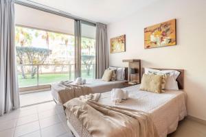 two beds in a room with a large window at Herdade dos Salgados Harmonia in Guia +41 photos