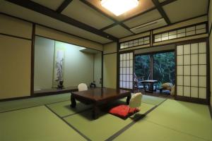 a room with a table and chairs and a window at Yumoto Ueyama Ryokan in Himeji