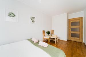 - une chambre avec un lit et 2 serviettes roses dans l'établissement Apart City Center - 3 Rooms - Parking Place, à Wrocław