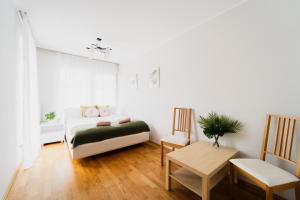 - une chambre avec un lit, une table et une chaise dans l'établissement Apart City Center - 3 Rooms - Parking Place, à Wrocław