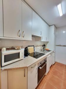 een keuken met witte kasten en een magnetron bij Apartamento Plaza España Gran vía centro in Madrid
