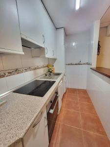 een kleine keuken met witte kasten en een wastafel bij Apartamento Plaza España Gran vía centro in Madrid
