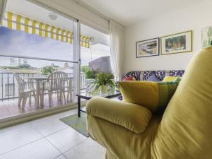 ein Wohnzimmer mit einem Sofa und einem Balkon in der Unterkunft Piso ideal para dos con balcón Platja d'Aro in Platja  d'Aro