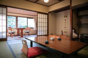 ein Zimmer mit einem Tisch und Stühlen sowie einem Esszimmer in der Unterkunft Yumoto Ueyama Ryokan in Himeji